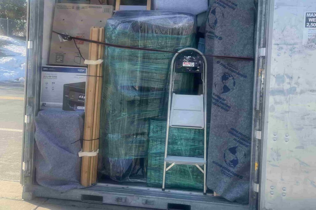 Packed PODS container with furniture and moving blankets, loaded by Edina movers.